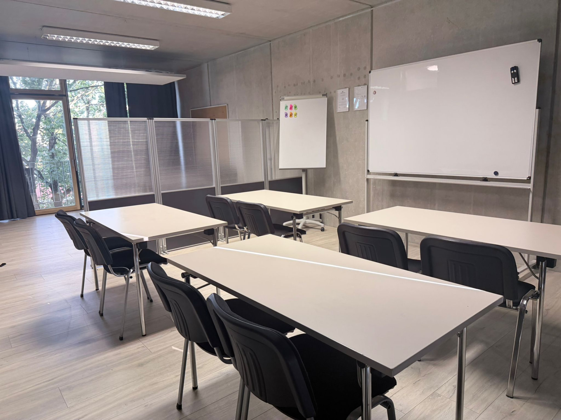 Großer Seminarraum mit Tischreihen und Flipchart